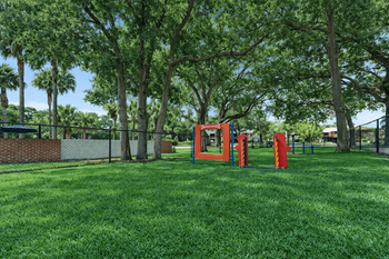 A playground with a red slide and a red climbing frame.